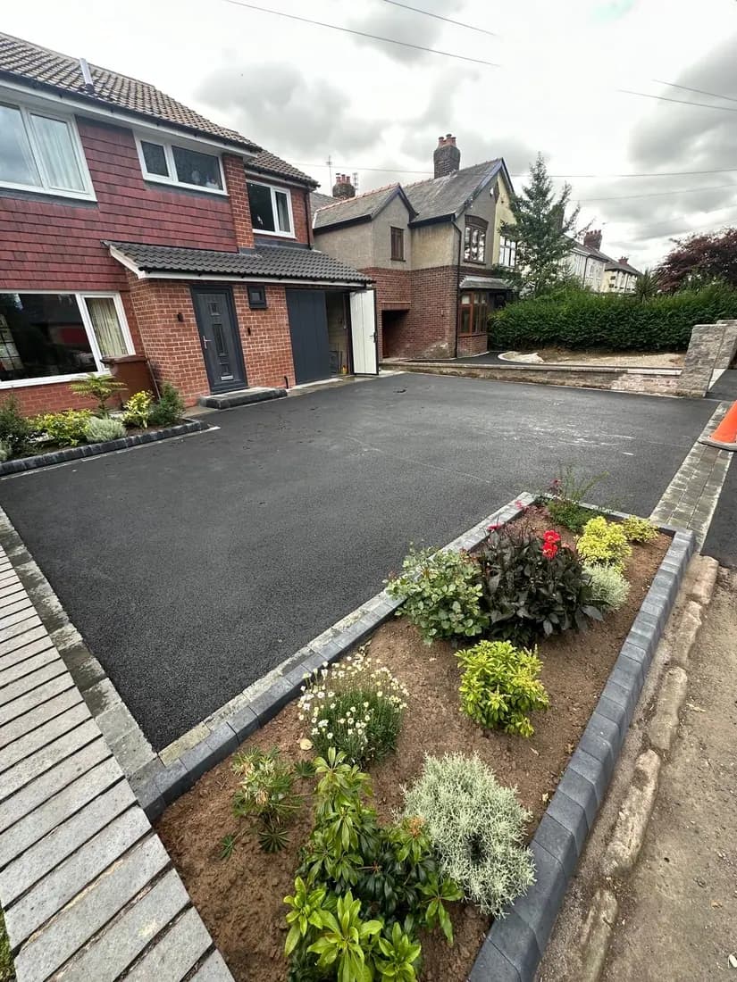 Newly laid tarmac driveway with block edging and a planted border